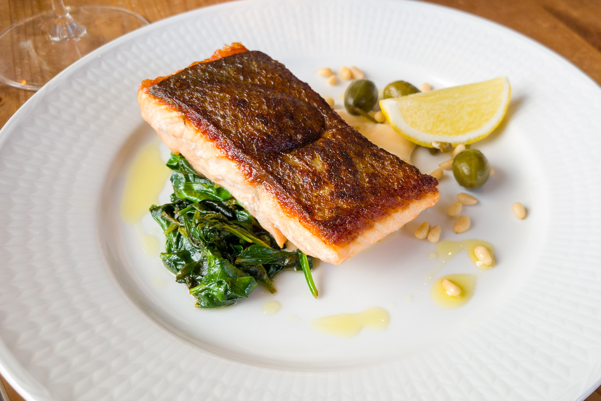 Knaperstekt Lax på sotad spenatbädd med srirachamajonnäs