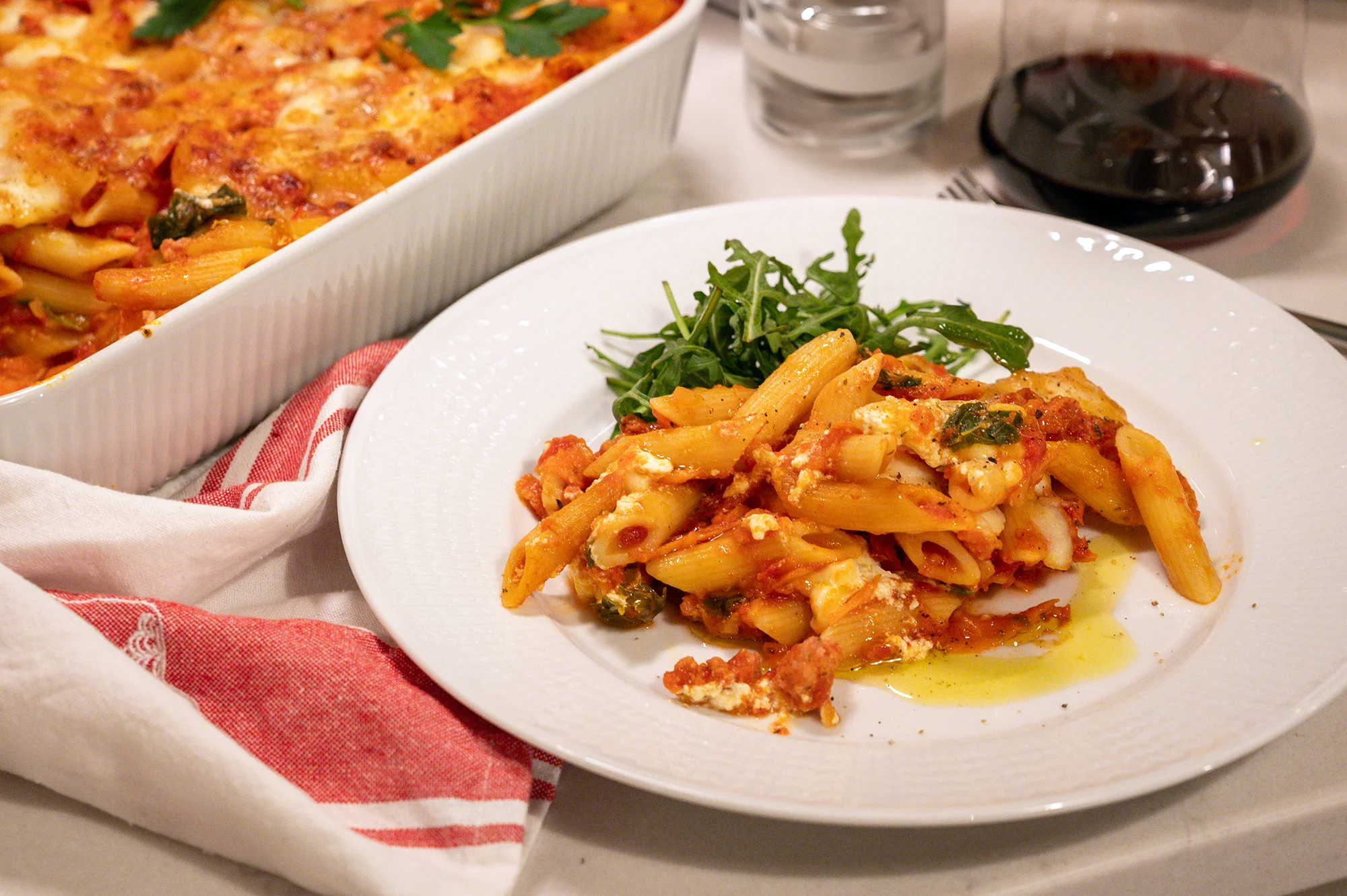 En krämig pastagratäng Ziti med salsiccia, fyllig tomatsås och smält mozzarella i en form.