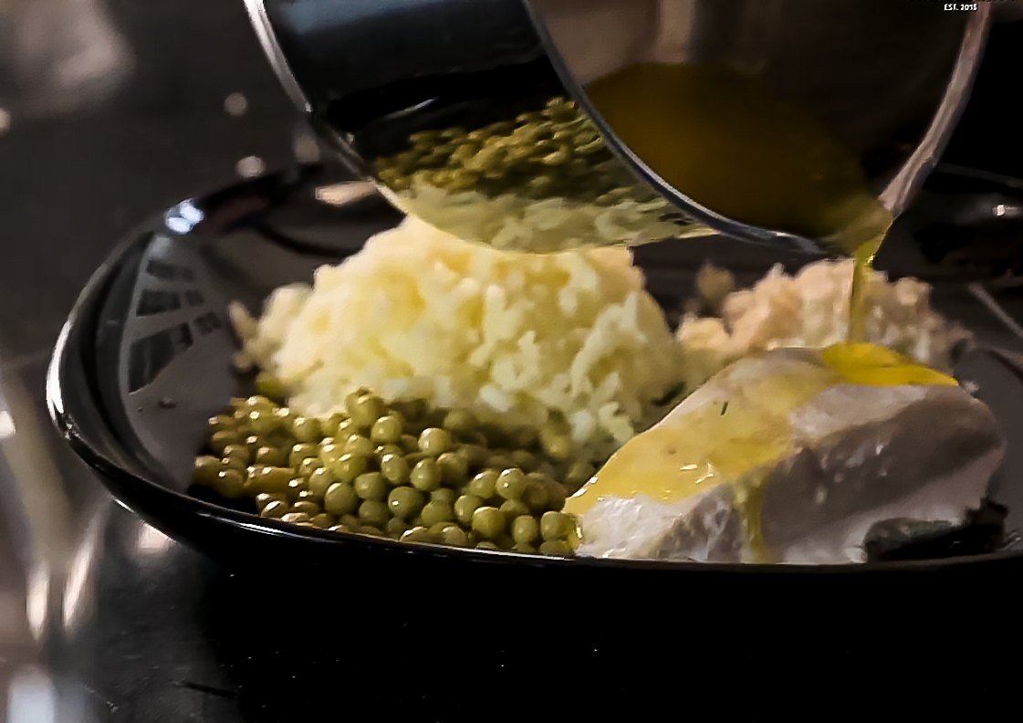 Ugnsbakad hälleflundra som hälls över med skirat smör, serverad med pressad potatis, gröna ärtor och pepparrot